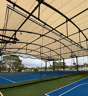 Dividing Curtain System for Covered Outdoor Learning Area (COLA) – RMA Sport - RMA Sport Retractable dividing curtain system under tensile roof on outdoor multi-sport court