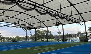 Foldable Net System Over Covered Sports Court – RMA Sport Installation - RMA Sport Foldable overhead net system installed above multi-sport court under tensile roof