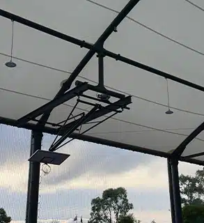 Retractable Side Netting on Covered Outdoor Court – RMA Sport Design - RMA Sport Side view of covered sports court with retractable side netting and steel frame structure