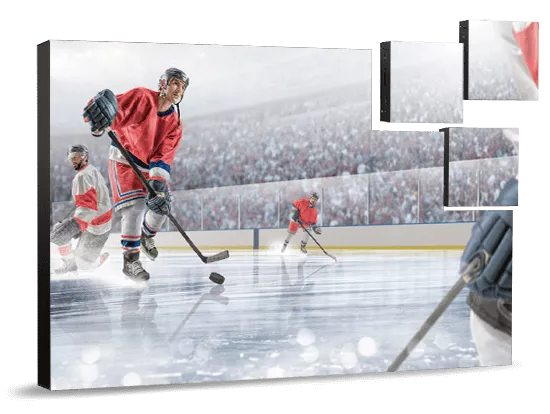 ecrans-video-modulespng - RMA Sport Ice hockey players in red jerseys skate on an indoor rink during a game, with the puck near the foreground and a busy crowd in the stands behind them.
